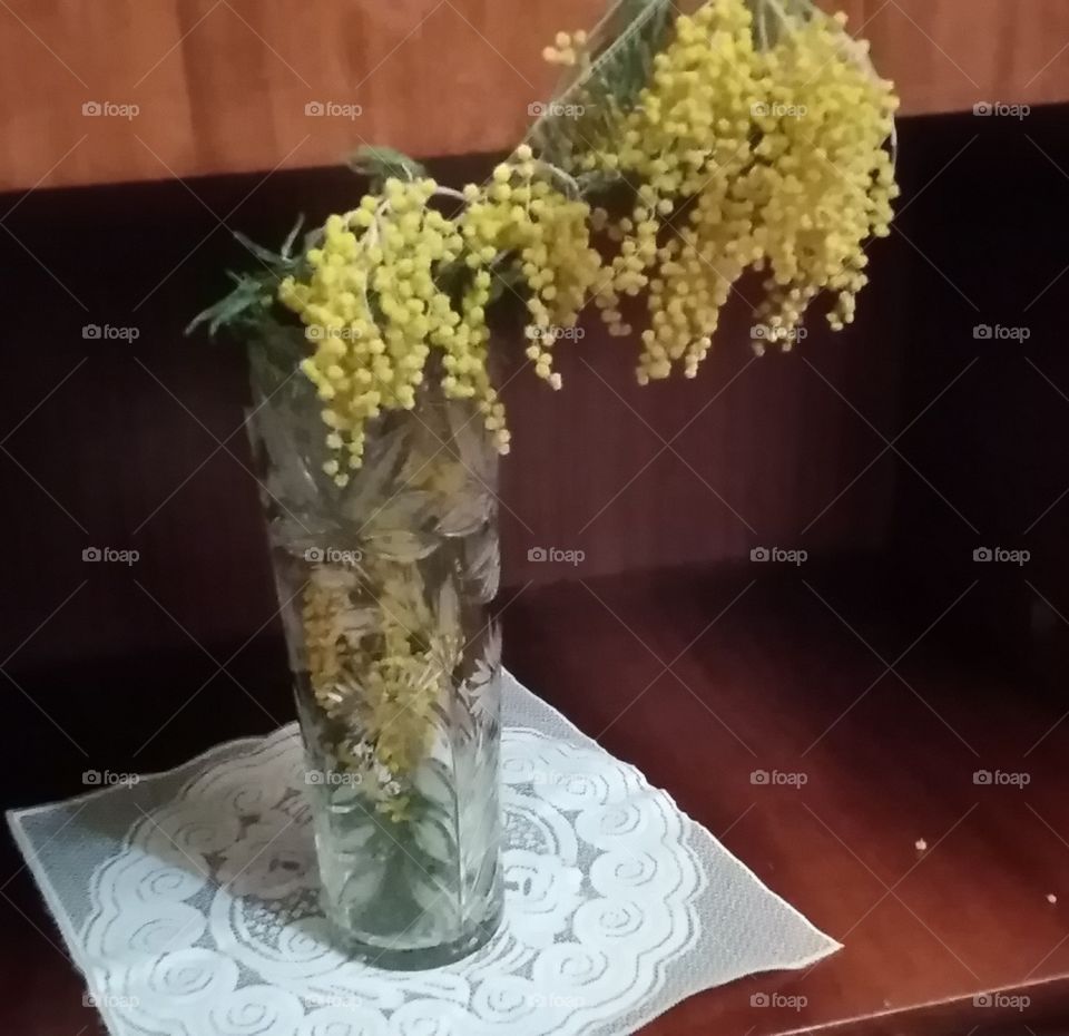Yellow flowers in glass vase.