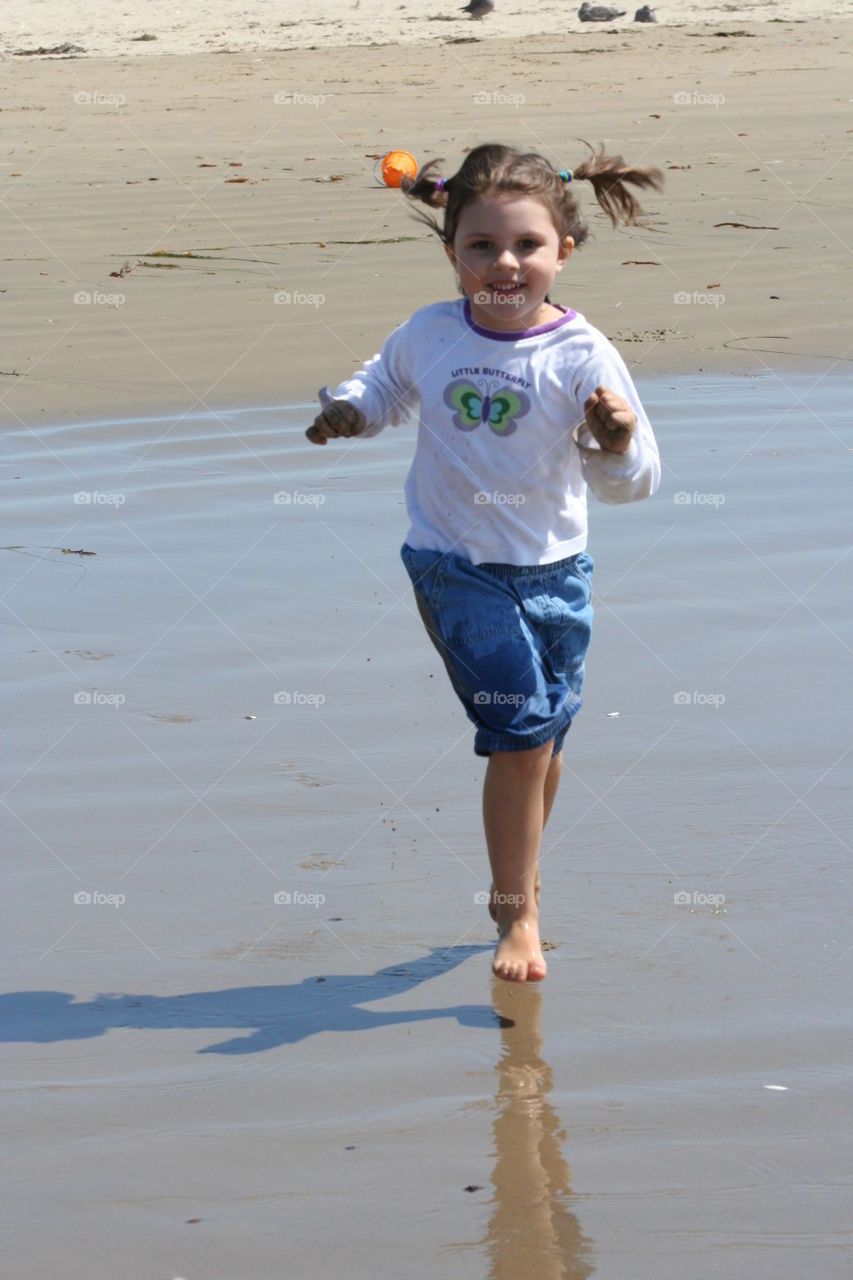 Girl running to the Ocean