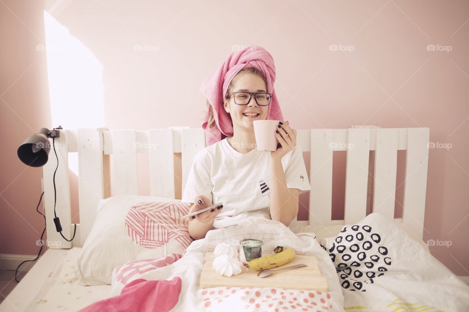 Girl Sitting on bed and eating breakfast