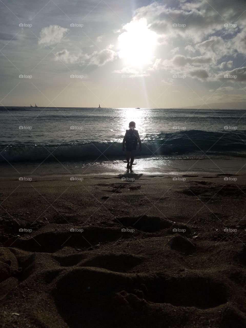Boy plays in surf at Waikiki Beach