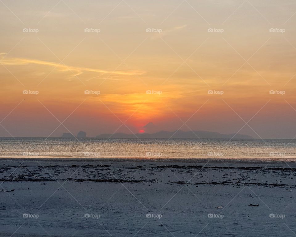Scenic view of beach against sunset sky