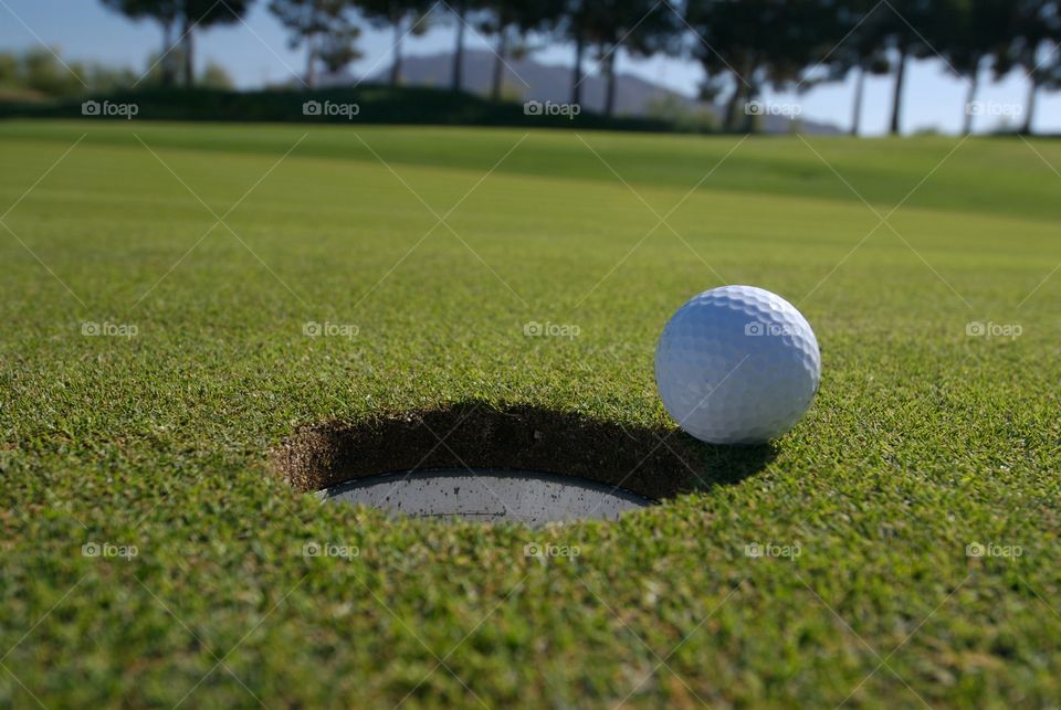 Golf ball on the edge of cup