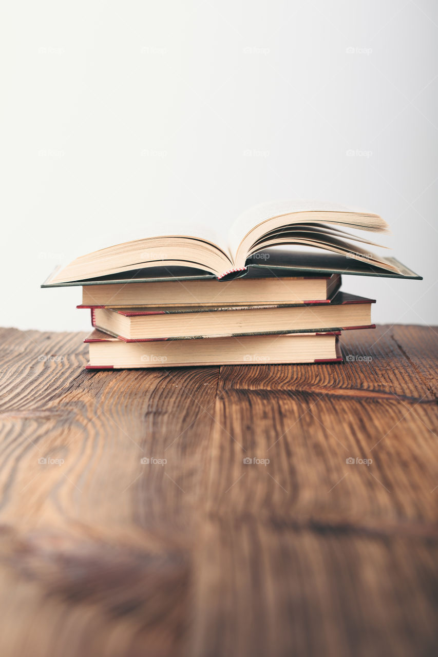 A few old books on wooden table in antique bookstore. Space for text