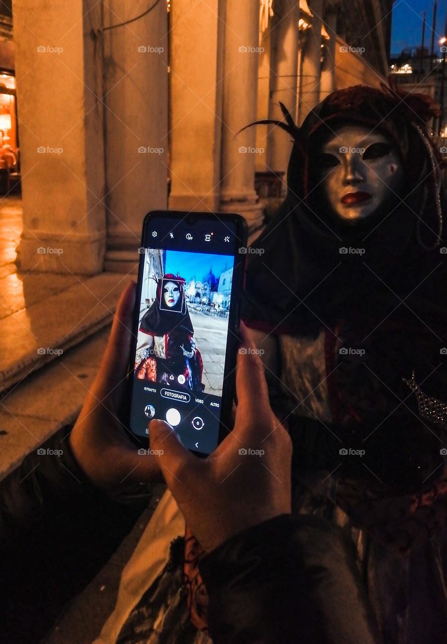 taking photo of Carnival mask