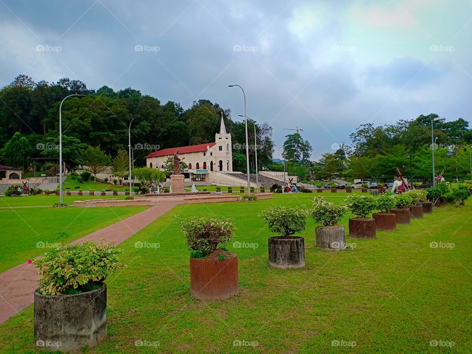 green grass at garden with background cloudy sky and a chapel of St. Anne in Penang Malaysia