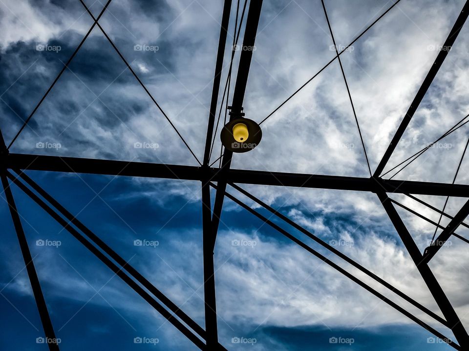 A view of the the sky and clouds from the perspective of standing on a historic pedestrian bridge.