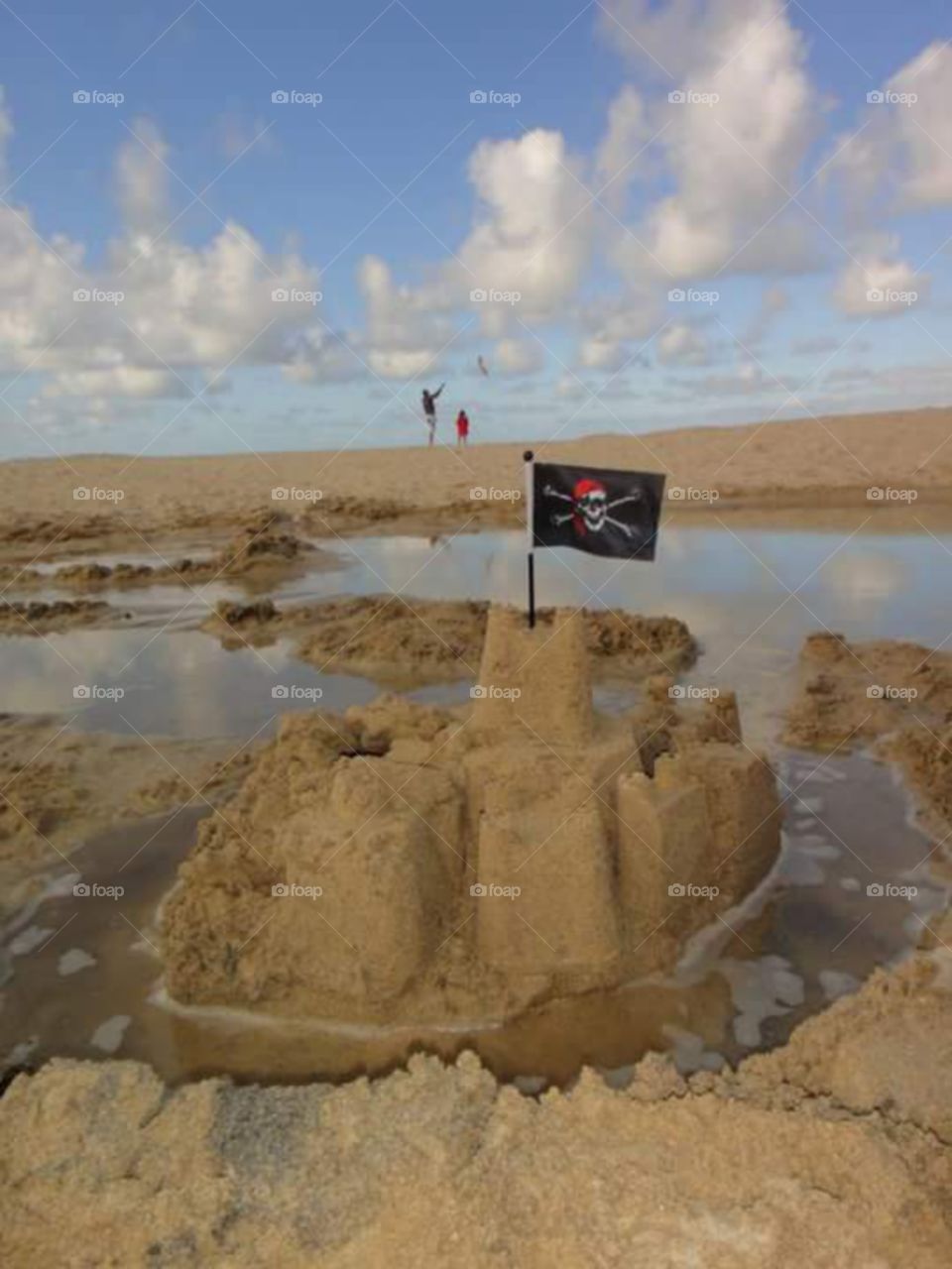kite flying and a sand castle with pirate flag on carvis bay beach