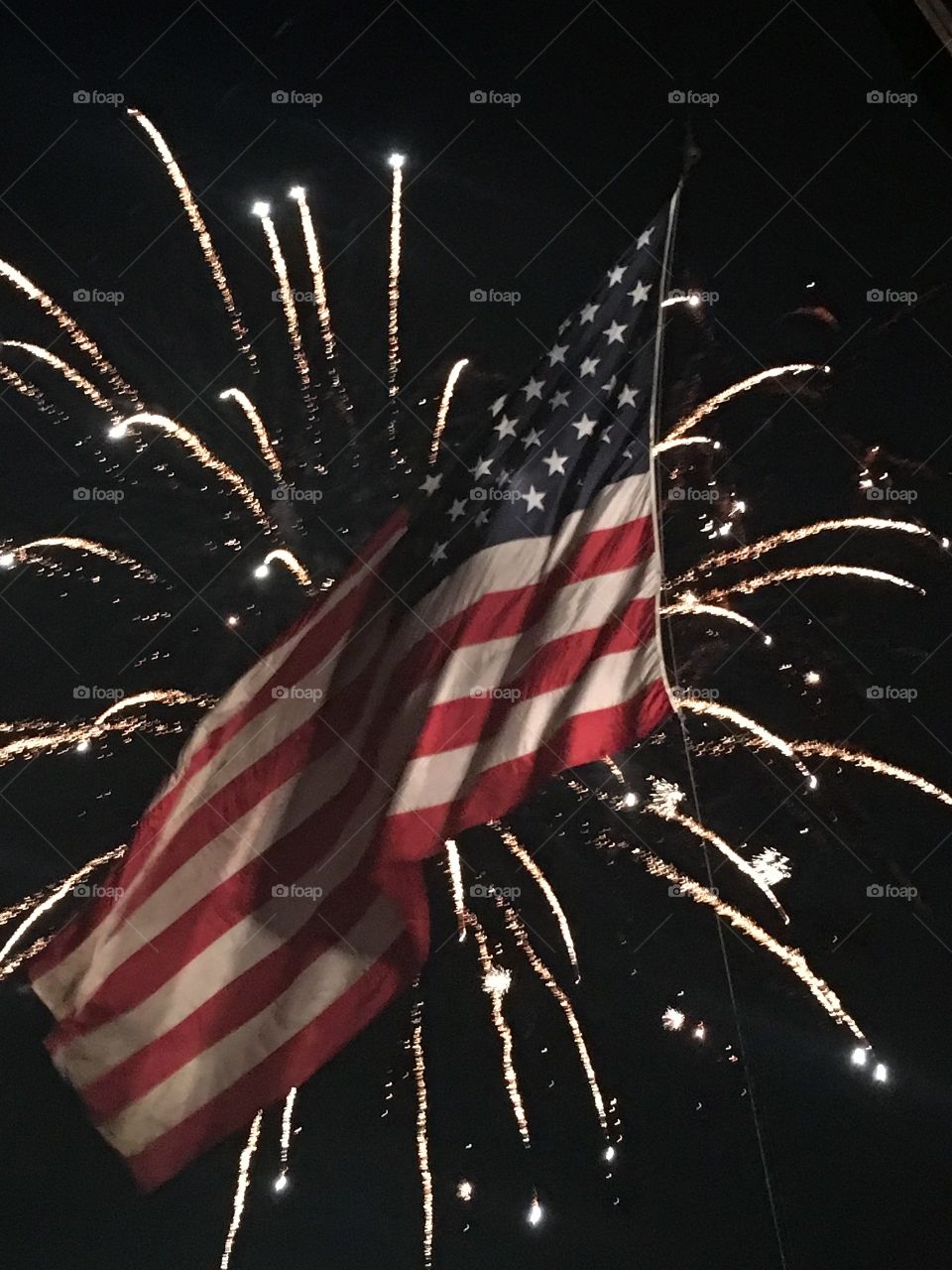 Fireworks behind American flag 