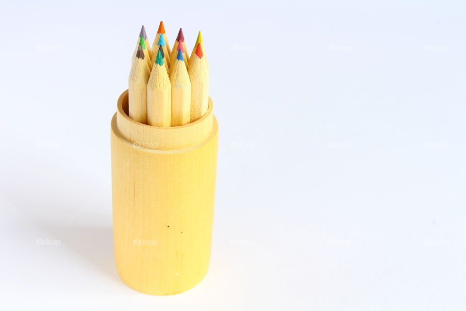 Group of color crayons in a wooden cylinder isolated macro