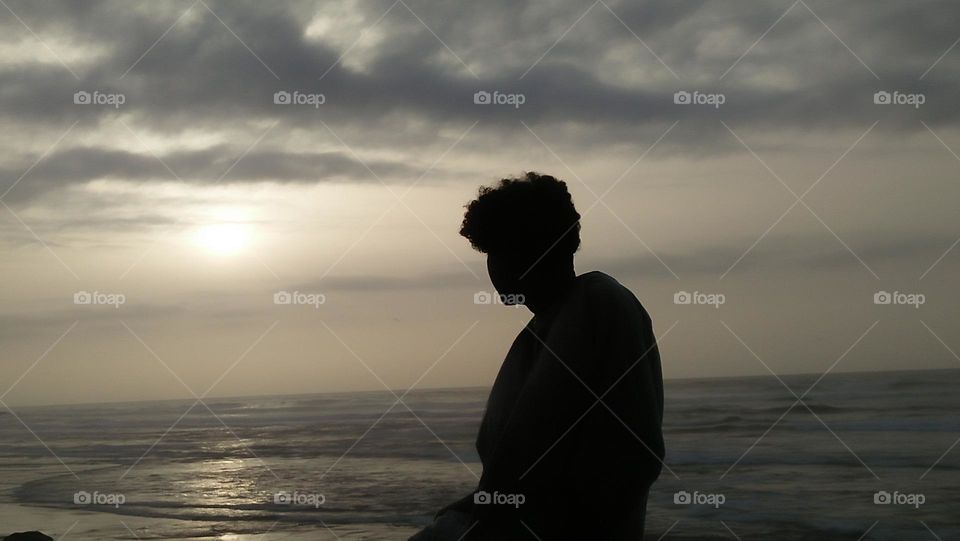 adult man is looking at beautiful sunset.