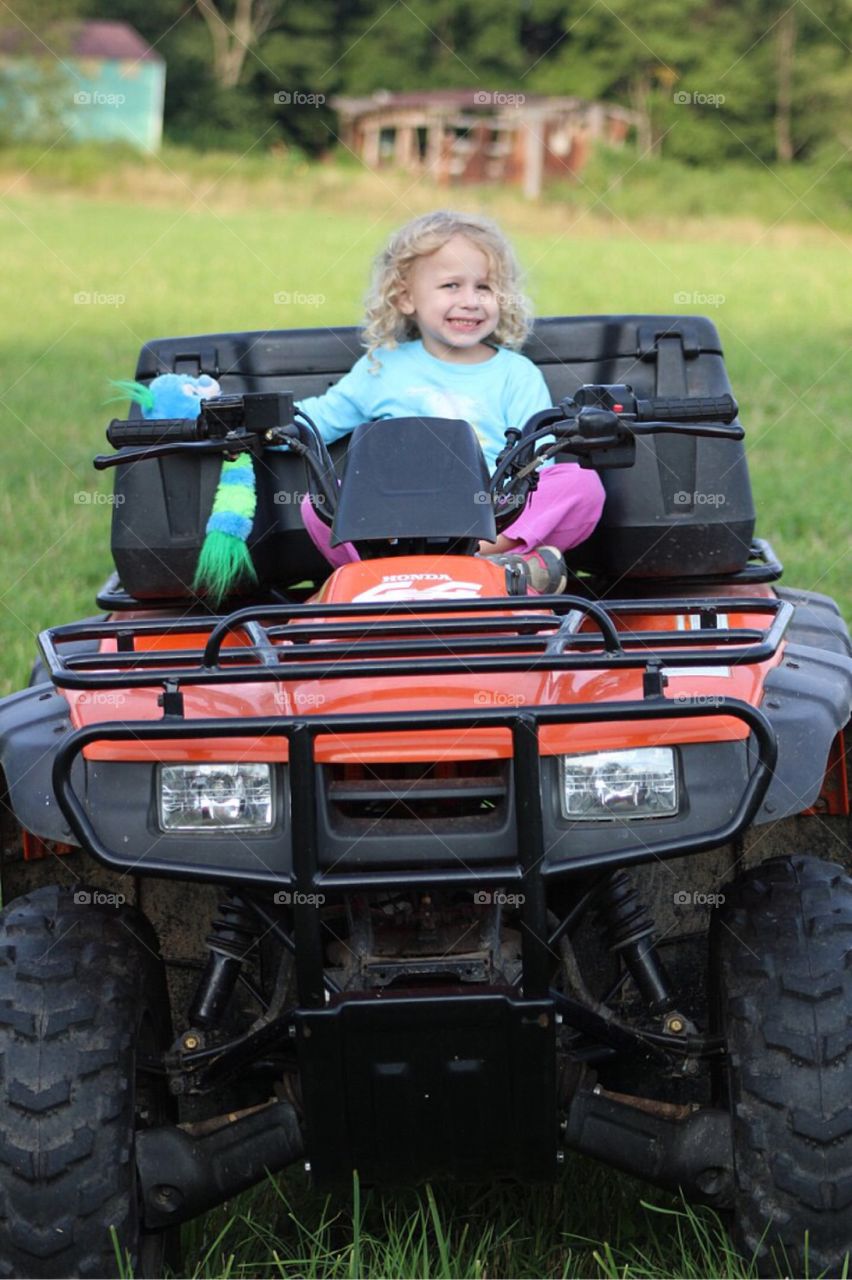 Smiling girl sitting in quadbike