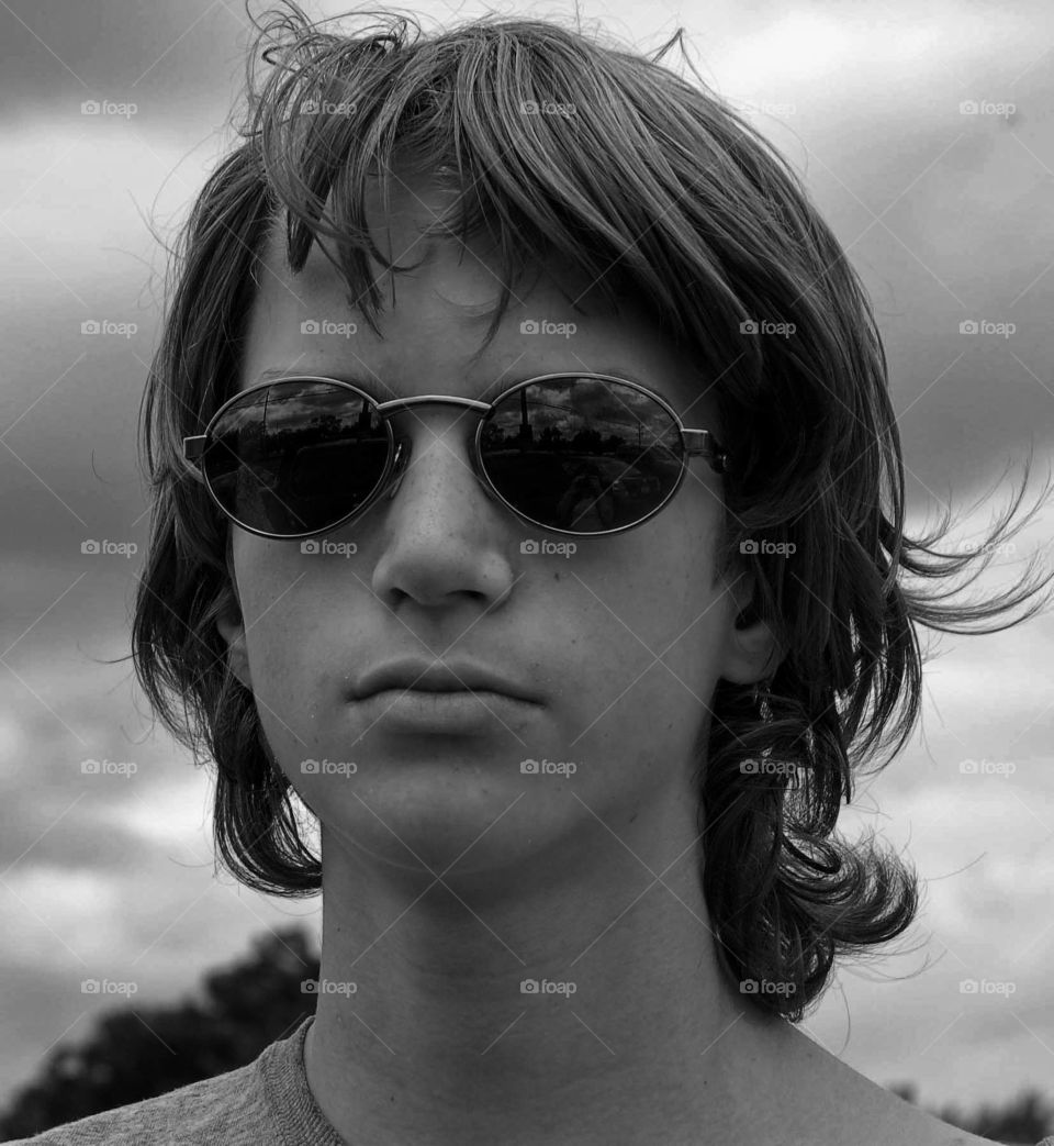 Young teenager wearing sun glasses outdoors . 