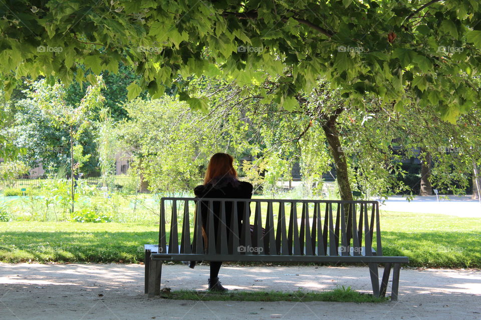 a lonely lady in a park in Paris.