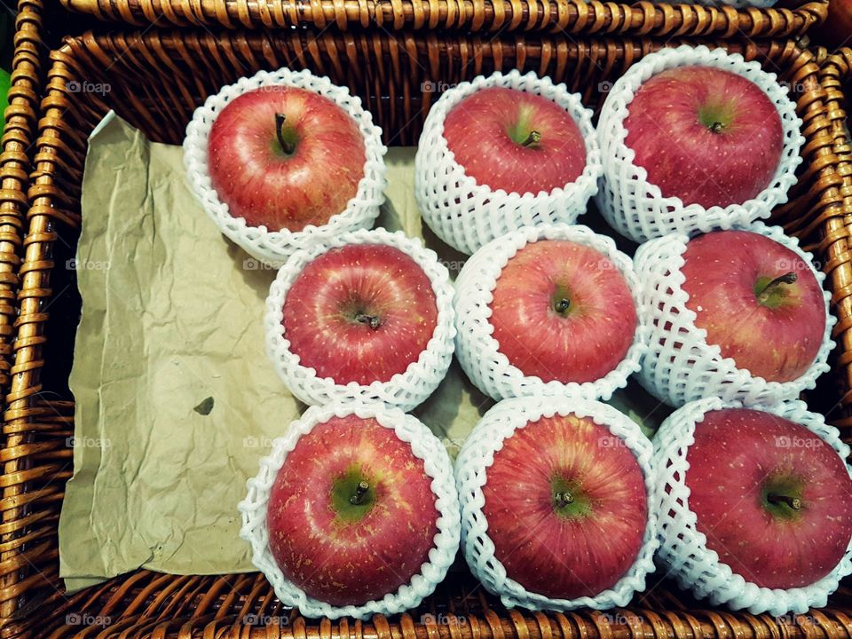Group of big red apples displayed in basket