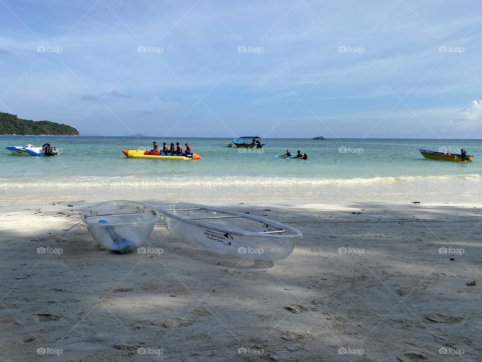 Transparent kayak on the beach on a sunny day.