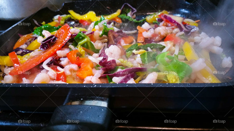 Steaming hot prawn and vegetable stir fry with sweet chilli sauce in a pan
