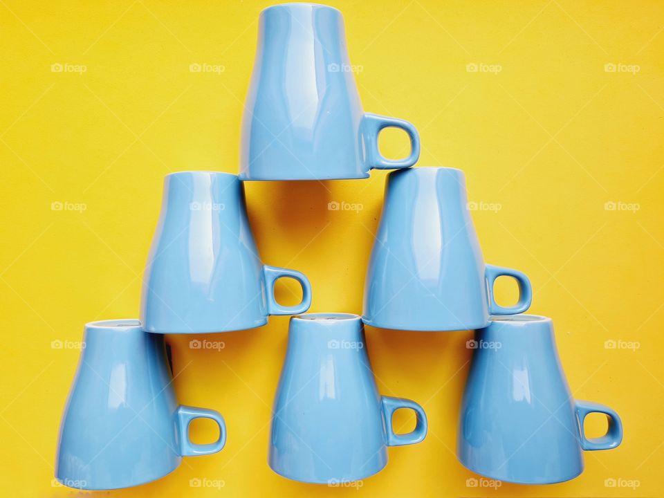 upside down cups on yellow background
