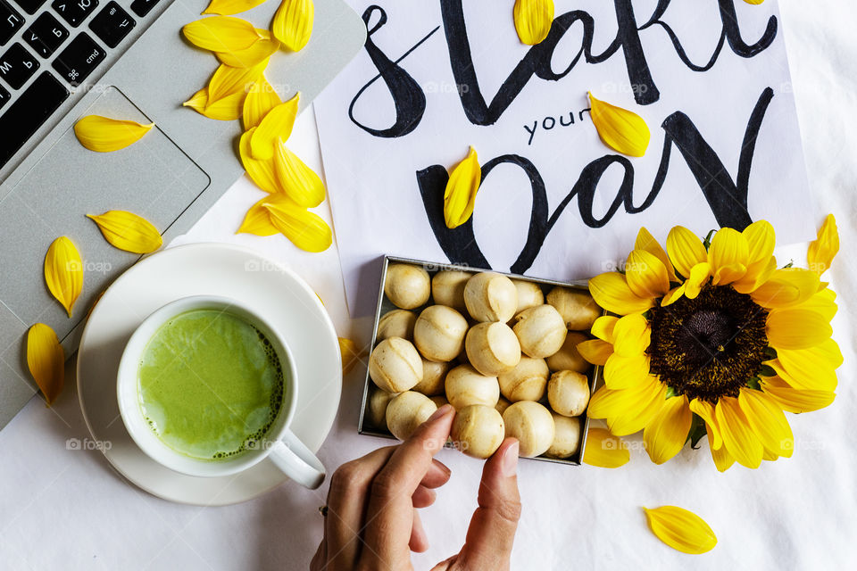 Flat lay with cookies, green matcha tea, sunflower 