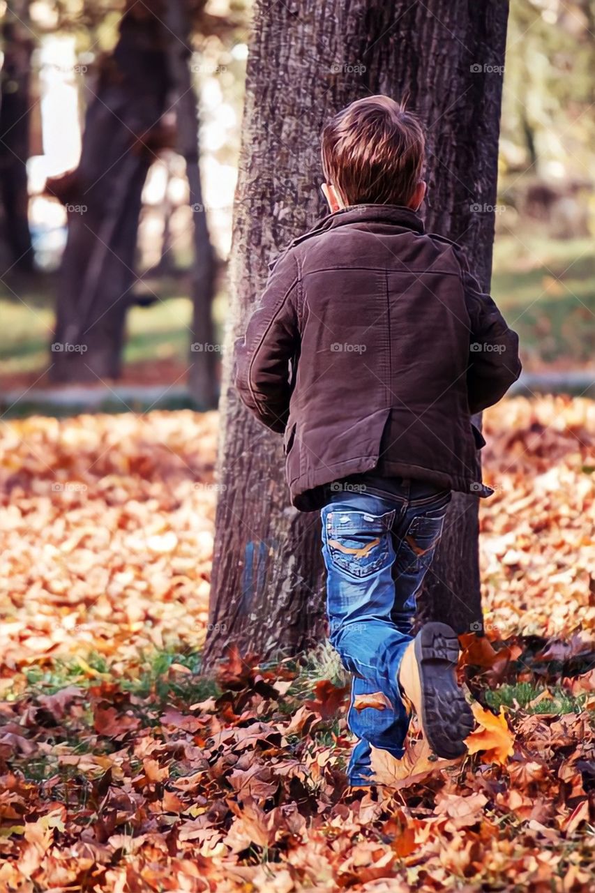 Autumn is coming. 

Boy running in the park on the fallen leaves of the trees. Very autumnal photo of the month of October.