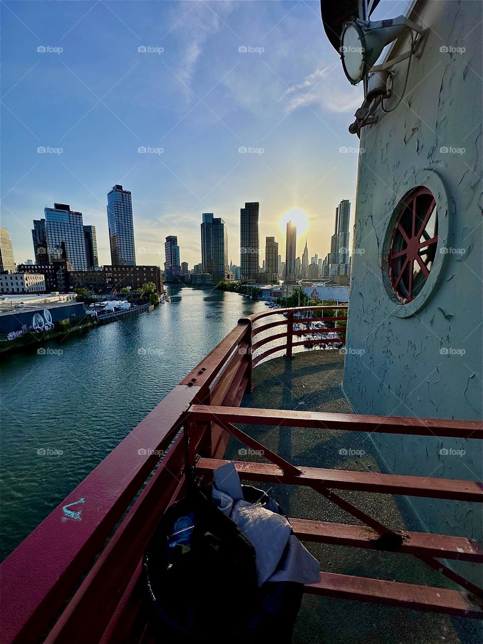 This is the center outpost of the “Pulaski Bridge” that connects “Greenpoint”, Bklyn to LIC, Queens overlooking “Newtown Creek”. Across the “E River” in the distance we see “Manhattan” including the “Empire State Building”. 2024. Hypnotic Productions