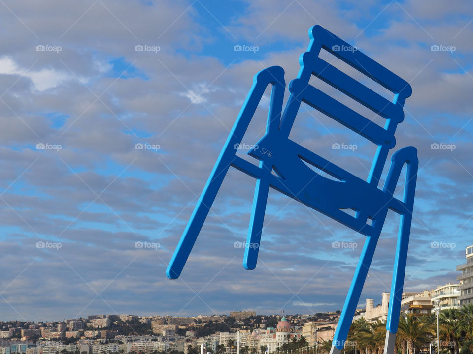 Iconic blue chair statue on the Promenade des Anglais in Nice, France.