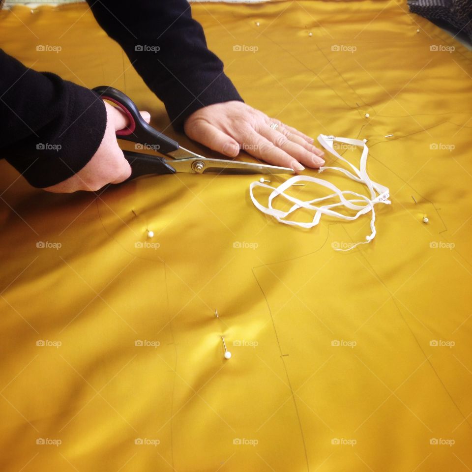 Hands cutting yellow silk