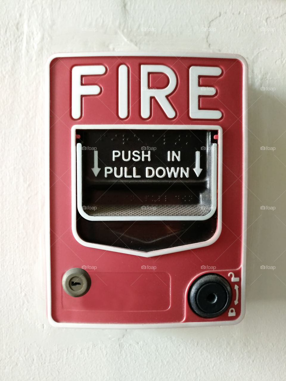 Fire alarm pull switch on the white wall.