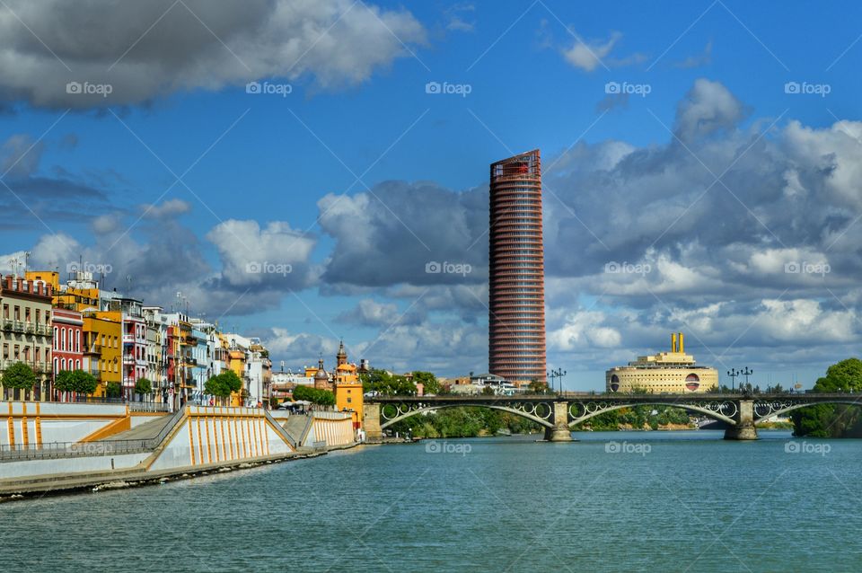 Triana. View of barrio de Triana, Triana Bridge, Cajasol Tower and the Maritime Museum from river Guadalquivir. Sevilla, Spain.