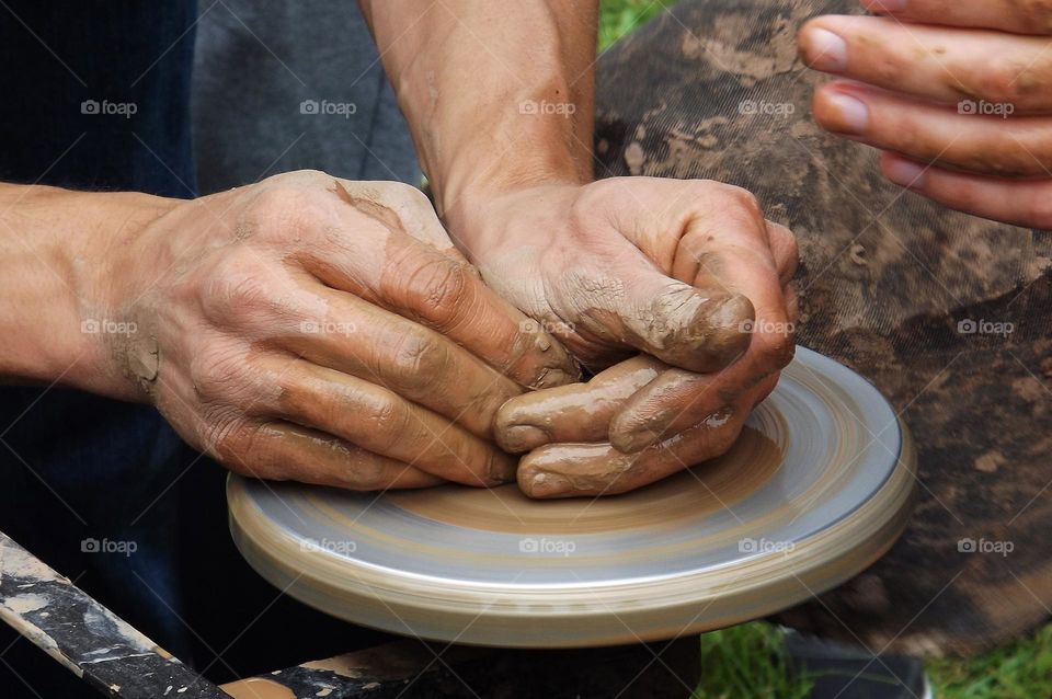 man makes pottery out of clay
