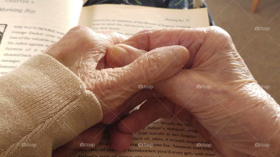 My lovely lady friend at the ripe age of 90 resting her hands as she chats in between reading her book.