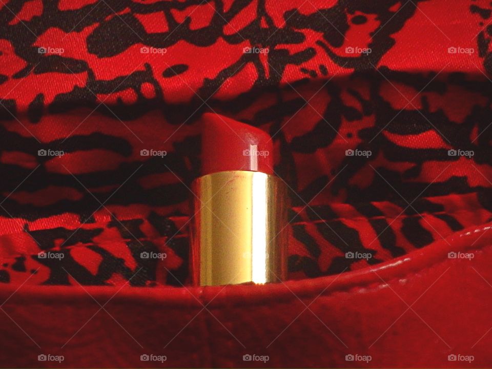 Closeup of red lipstick in red bag