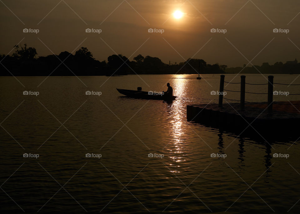 fisherman on the lake at afternoon sunset