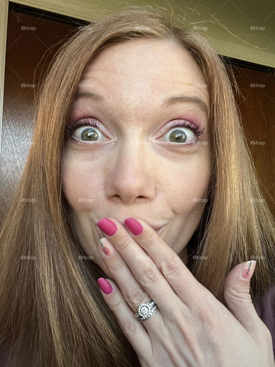 A surprised woman with adorable gel nail polish manicure 