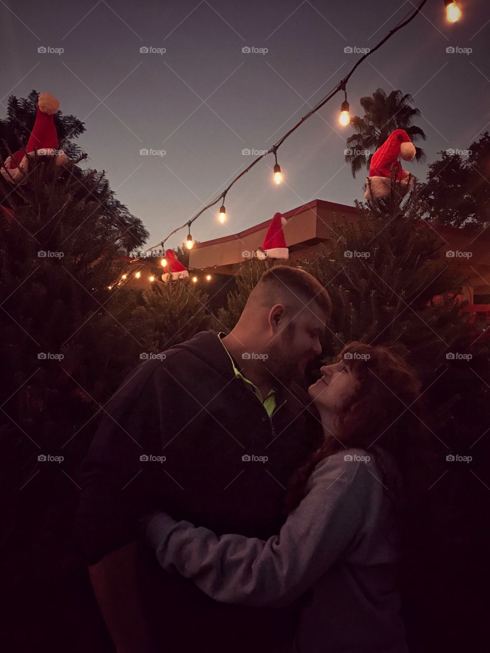 Sharing special moments with my husband in a Christmas tree patch lighted with twinkle lights overhead. 