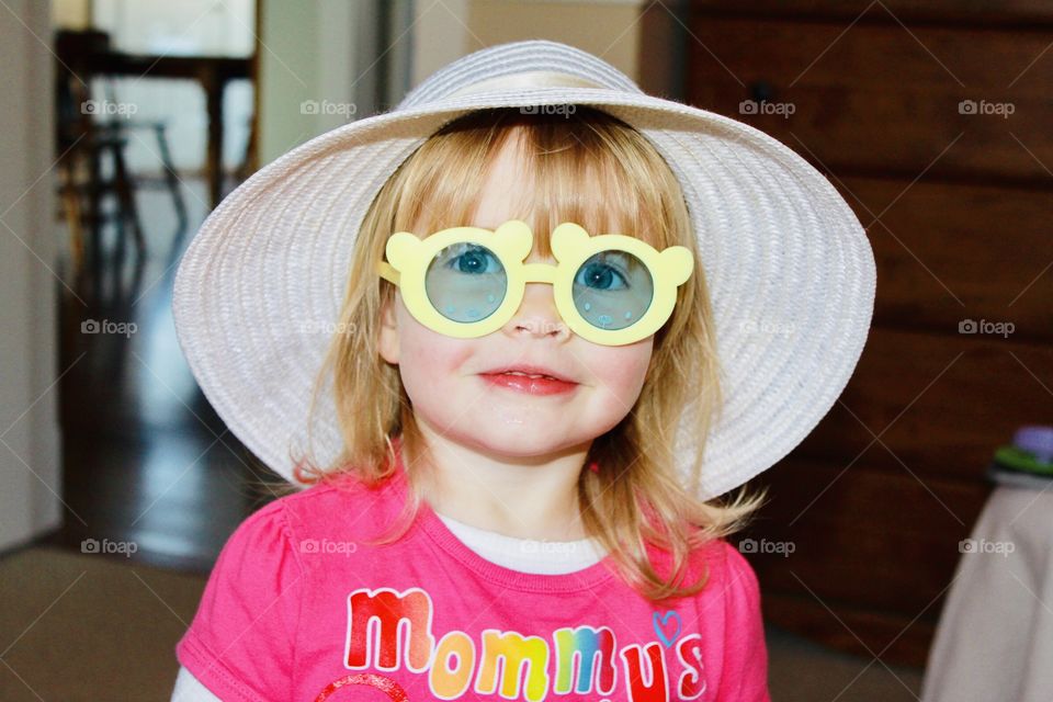 Darling sweet little girl playing with her silly yellow circular sunglasses on! 