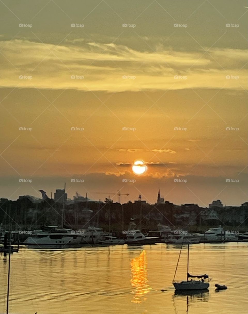 Breathtaking sunrise over the harbor. Local boats anchored at the marina. Cruise ship anchored in the distance. 