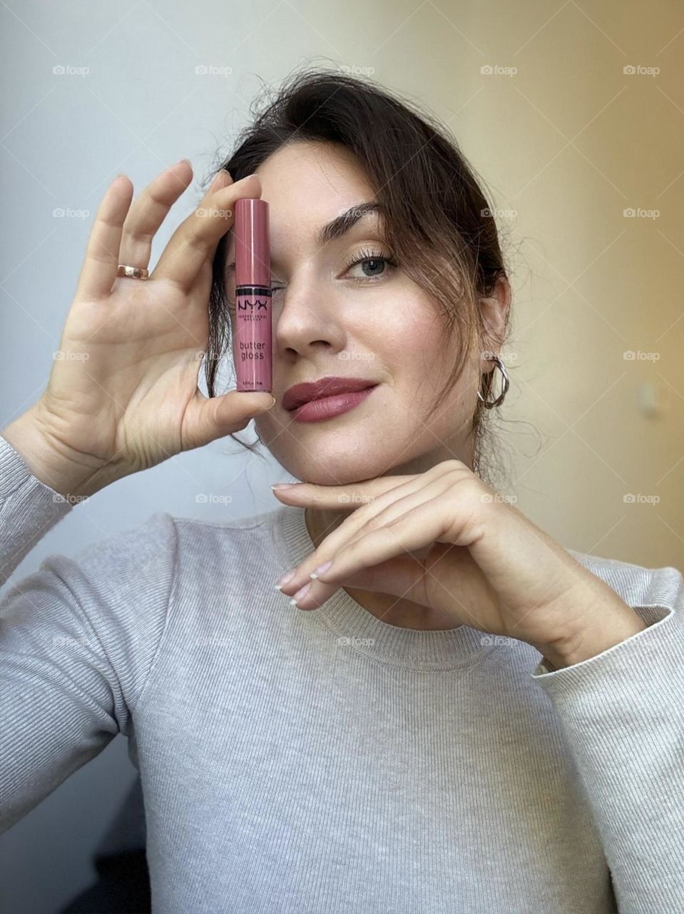 Woman’s portrait with product, girl holding a lipstick in her hands 