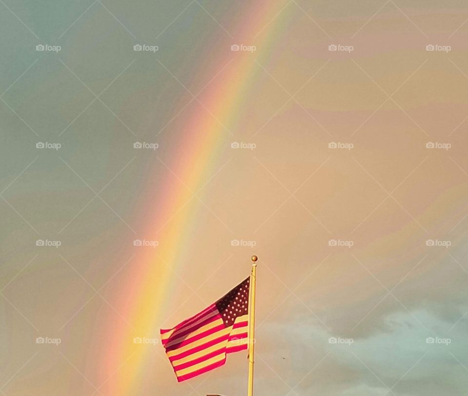 Rainbow, with Old Glory waving in the foreground.