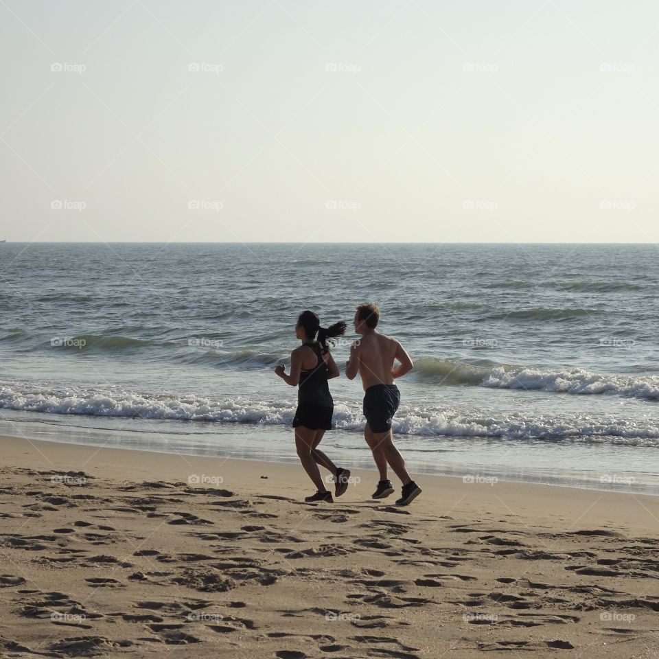 couple running on the beach in summer