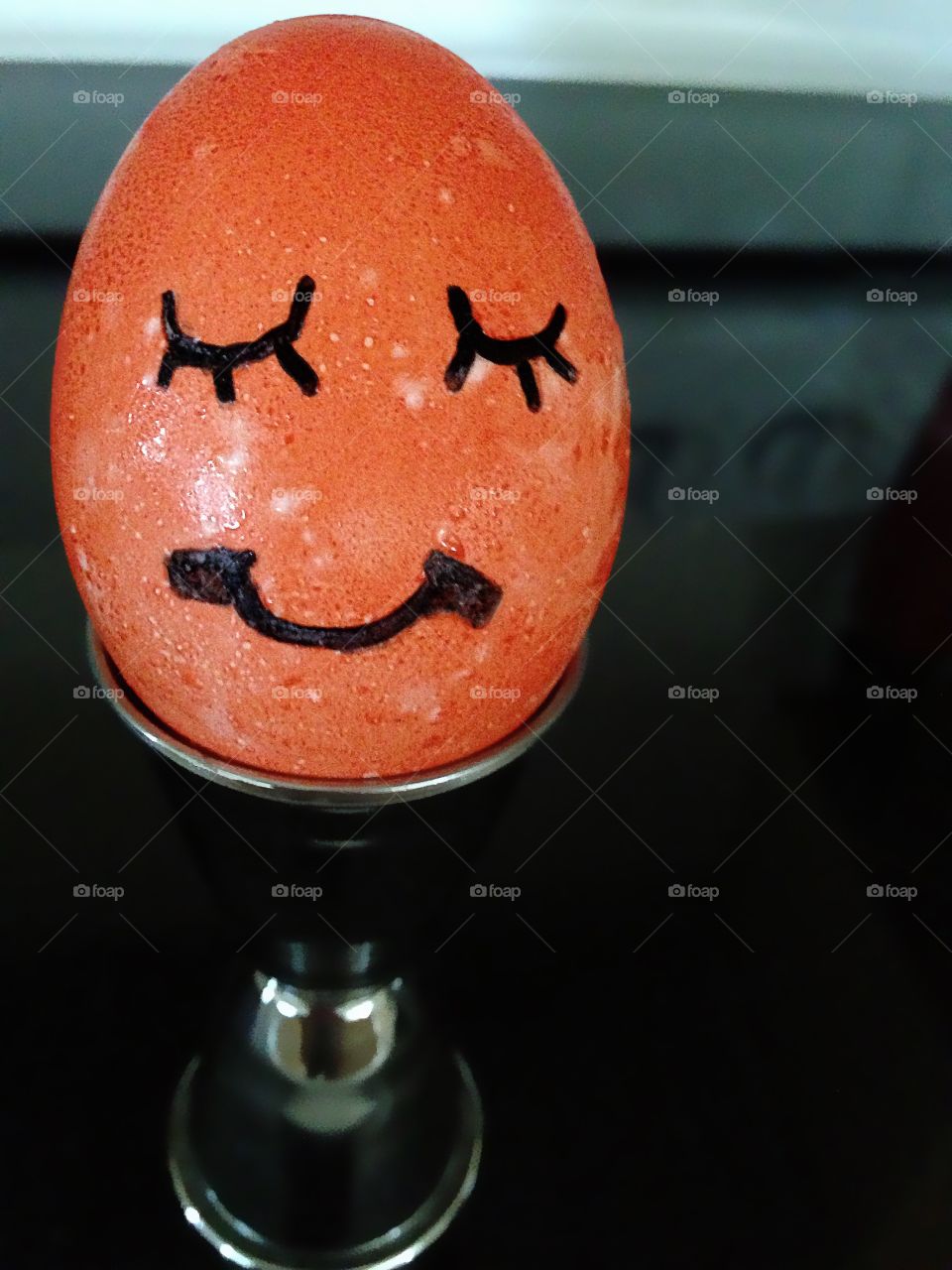 Orange and festive hard boiled egg with a big smile.