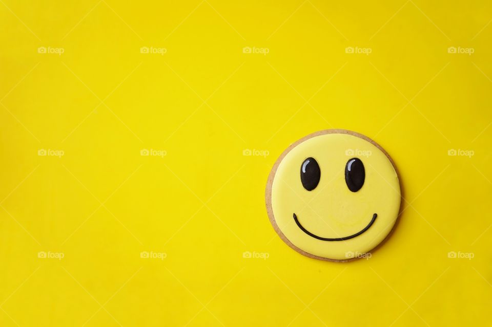 Yellow cookie on yellow background 