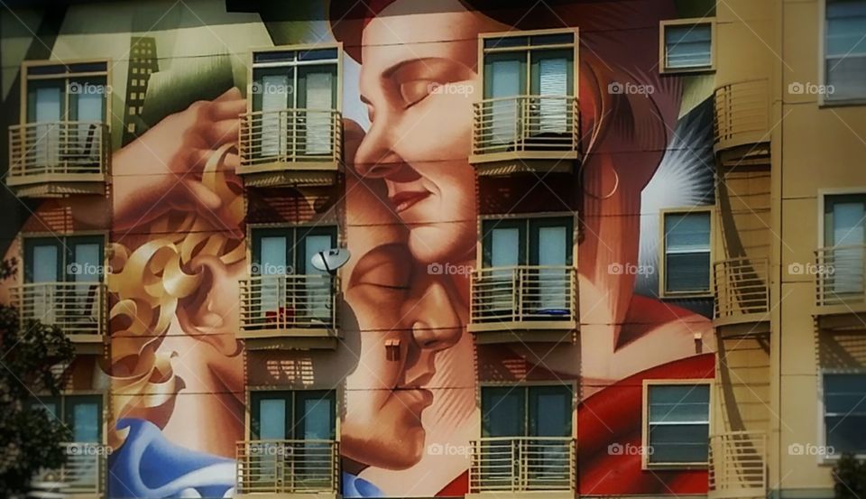 Urban color love a mural on the side of an apartment building in Dallas Texas of a woman and man embracing