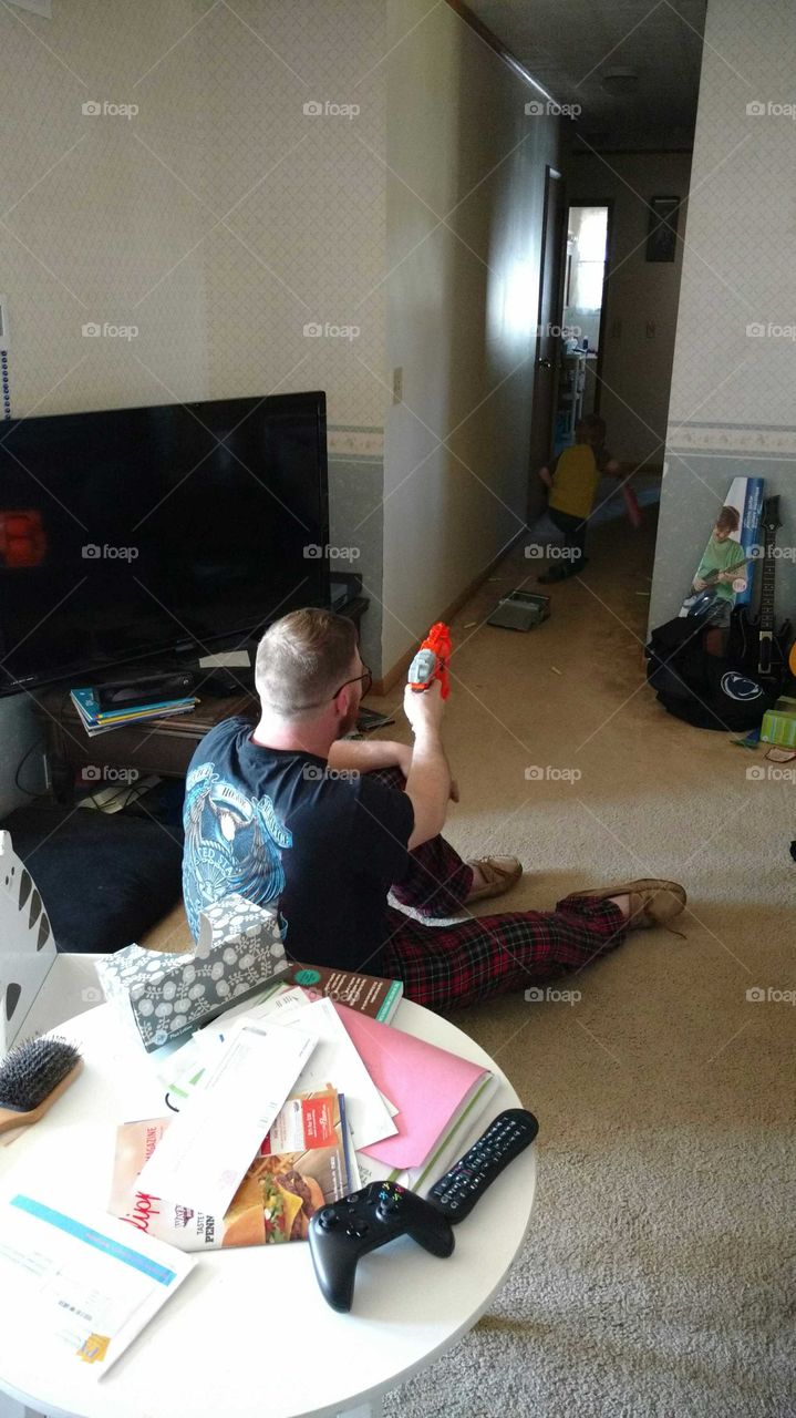 man plays dart guns with boy