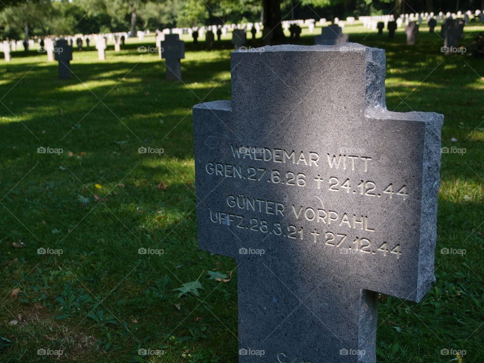 A closeup of a finely carved tombstone of fallen German Soldiers in a beautifully landscaped cemetery outside of Luxembourg City on a nice summer day. 