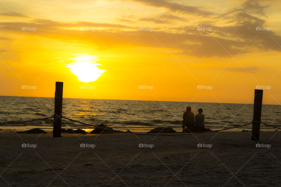 romantic sunset. an older couple enjoys the sunset on the beach