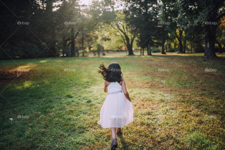 Little girl in white dress running