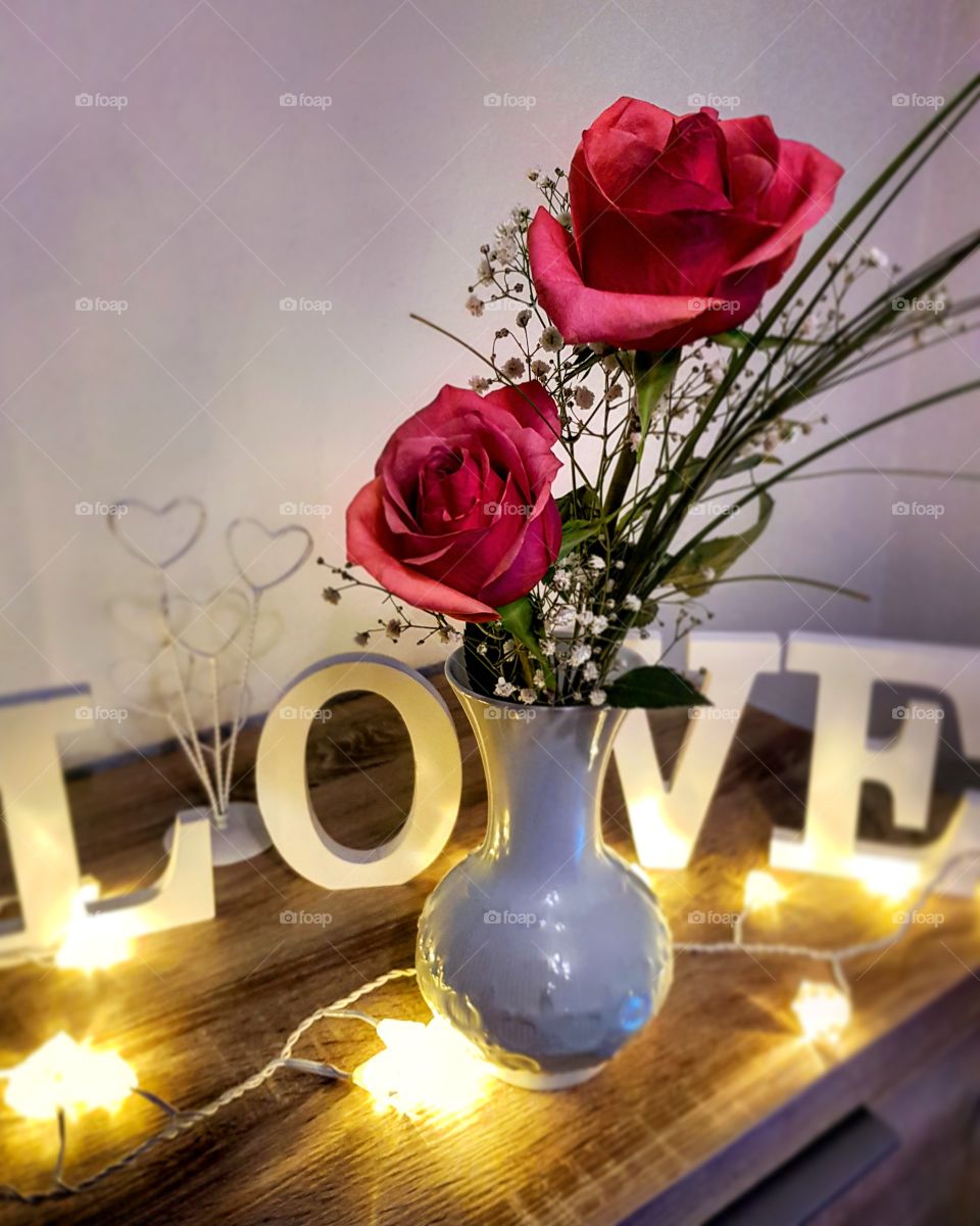 romantic arrangement with love, hearts, light and flowers