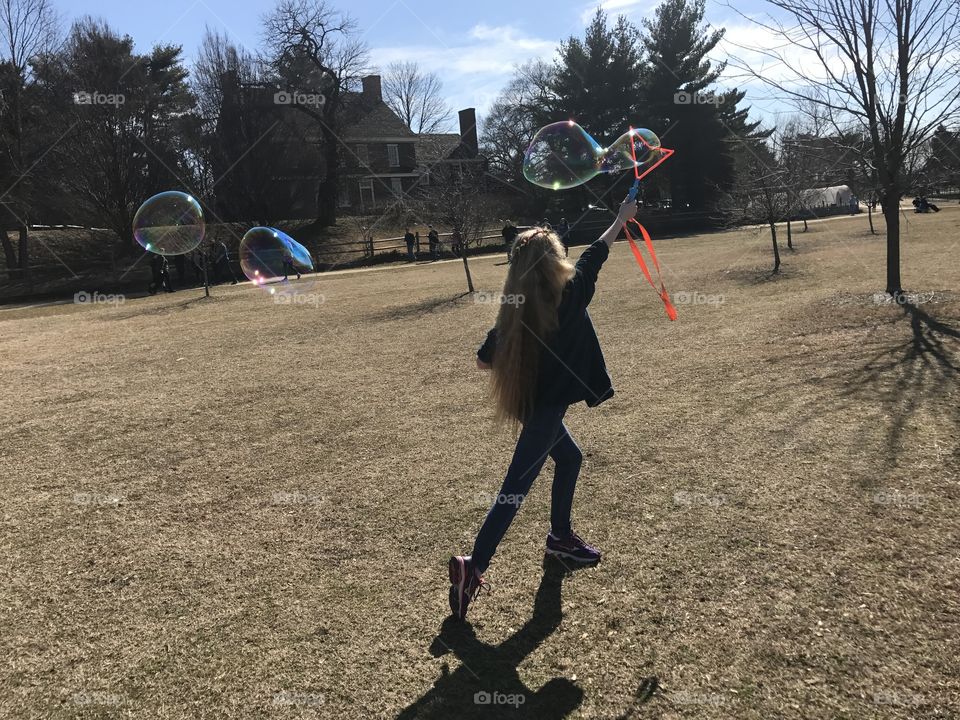 Girl running making giant bubble