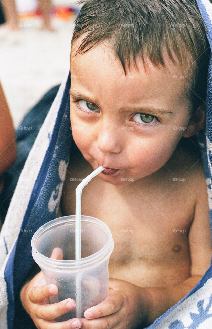 Boy drinking a juice. Boy drinking juice using a drinking straw