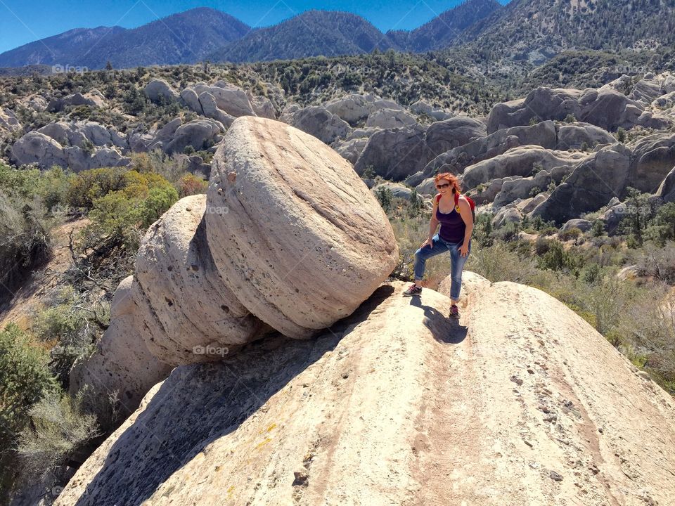 Female hiker posing near rock